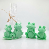 Adorable handmade green frog soaps by The Angelina Store. Two cute and detailed frog-shaped novelty soaps in a vibrant light green color. The larger frog features delicate flower details on its belly while the smaller frog has a charming ruffled collar. Whimsical, high-quality artisan soaps perfect for kids, frog lovers, bathroom decor, or as a fun unique gift.