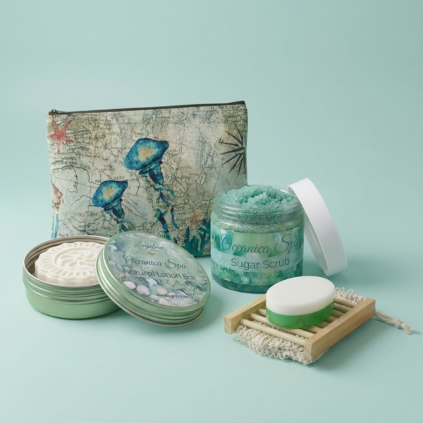 Oceanica Spa Collection self-care gift set by The Angelina Store. Beautiful arrangement showcasing the Oceanica Spa Sugar Scrub in a clear jar, Natural Lotion Bar in a green tin, and coordinating ocean-themed pouch with jellyfish design. Includes a white and green soap bar on a wooden soap dish. Luxurious sea-inspired skincare products in soothing seafoam green tones, perfect for spa routines, relaxation, and gifting.