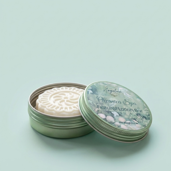 Oceanica Spa Natural Lotion Bar by The Angelina Store. Luxurious solid lotion bar in a beautiful light green metal tin with elegant seashell-themed lid. Creamy white embossed lotion bar made with natural butters and oils for deep hydration. Part of the calming Oceanica Spa Collection, perfect for nourishing dry skin while delivering a light, fresh ocean-inspired scent. Shown on a rustic whitewashed wooden surface with rolled towels and natural elements.
