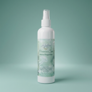 Oceanica Spa Home Fragrance Room Spray by The Angelina Store. Elegant white spray bottle with beautiful seafoam green label displayed on a wooden windowsill with ocean view. Premium room spray featuring calming ocean-inspired fragrance, part of the luxurious Oceanica Spa Collection. Natural home fragrance product styled with seashells, stones, rolled towel, and a lit wax warmer creating a serene coastal atmosphere.
