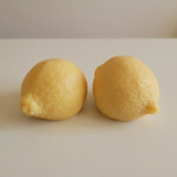 Two hyper-realistic lemon soaps from The Angelina Store. These incredibly detailed novelty soaps are shaped and textured to look just like fresh lemons, complete with natural-looking dimples and stem. Fun and whimsical handmade soaps ideal for guest bathrooms, kitchen sinks, or unique gifting.