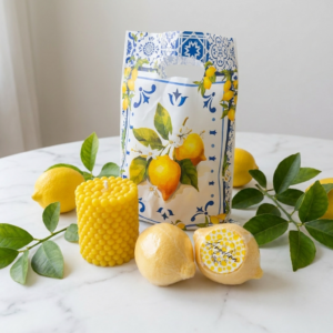 Limoncello Crème Soap & Candle Gift Set by The Angelina Store. Bright and cheerful collection featuring a vibrant yellow bubble texture pillar candle, two hyper-realistic lemon-shaped soaps (one beautifully wrapped with signature label), and a coordinating lemon-themed gift bag. Fresh, zesty Limoncello Crème scented soaps and candles with natural citrus fragrance, perfect for kitchen, bathroom, or as a luxurious summer gift. Bright, sunny, and inviting handmade lemon gift set.
